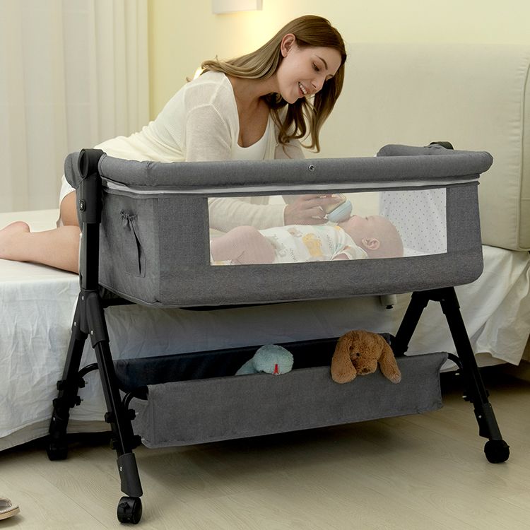 Mother feeding her baby beside a BCOL bassinet