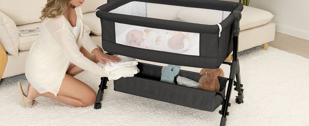 Restocking diapers in the basket of a Dark Grey BCOL bassinet