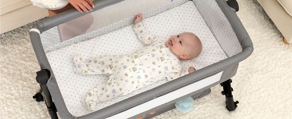 Baby resting in a Grey BCOL bassinet