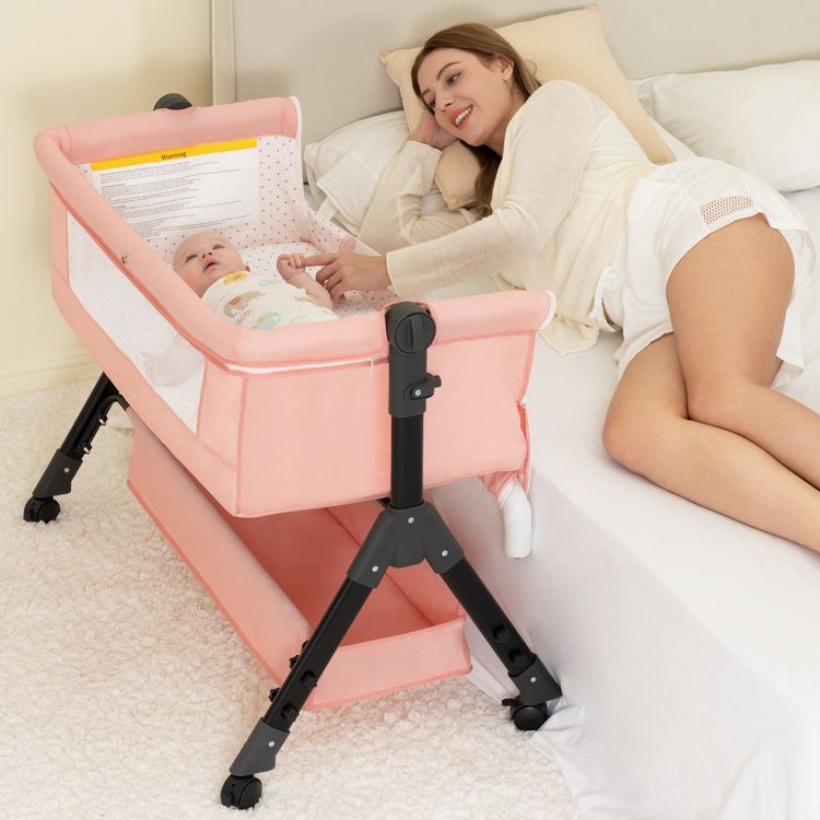 Pink BCOL bassinet attached to the side of an adult bed